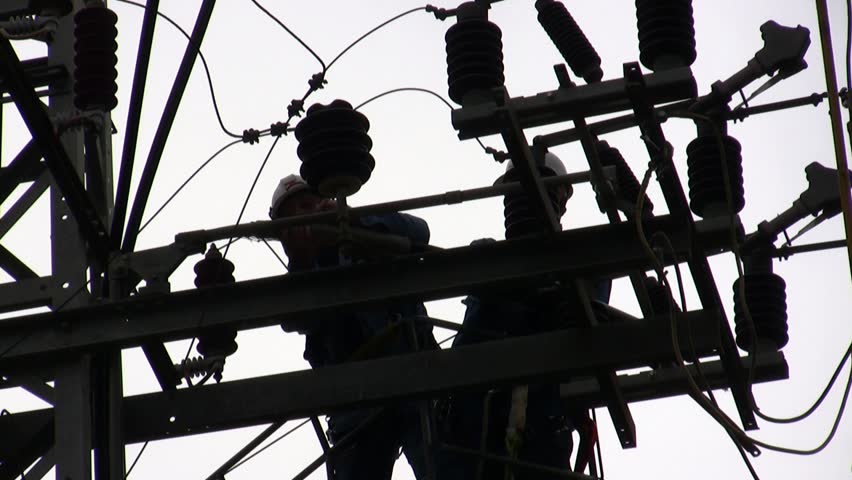 Electricians in a bucket fixing high voltage electrical lines