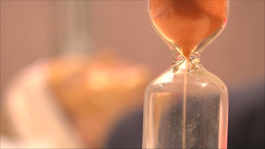 hourglass in the foreground with the patient behind