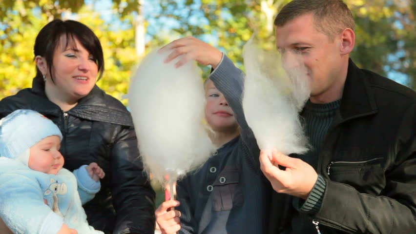 young family enjoying cotton candy at the fair