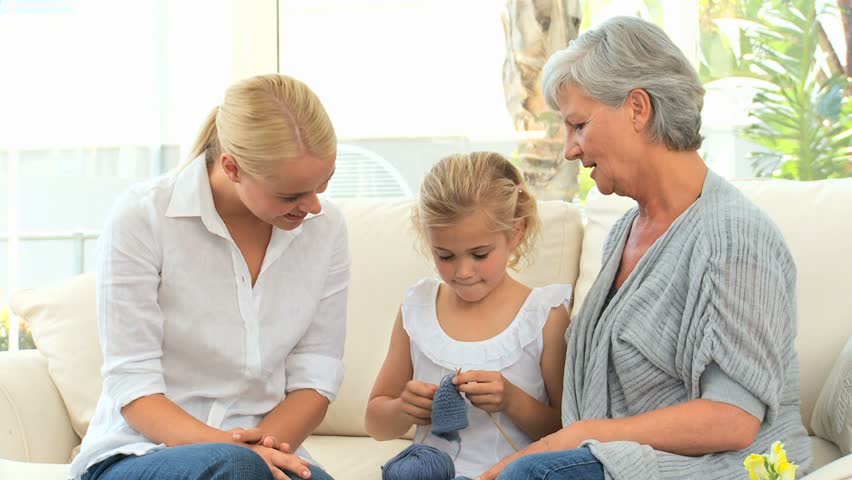 Girl learning to knit with her mother and Grandmother