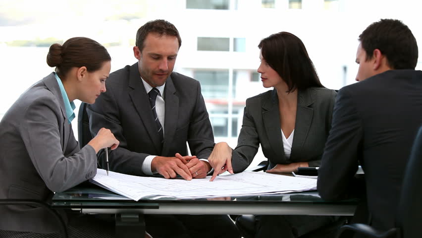 Businessmen and businesswomen working together on a document