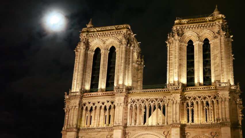 Notre Dame Cathedral, behind night sky and moon clouds