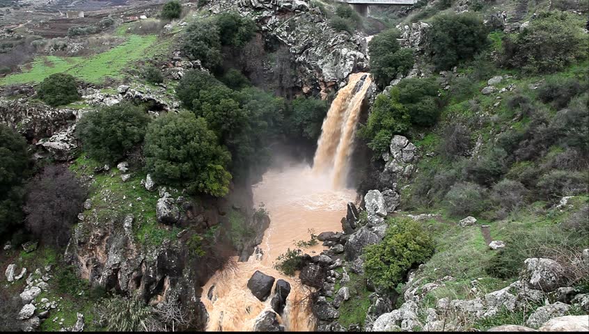 Banias Falls in the winter at the Golan Heights (Israel). Orange color of water because of washout of the earth from fields as a result of heavy rains.  