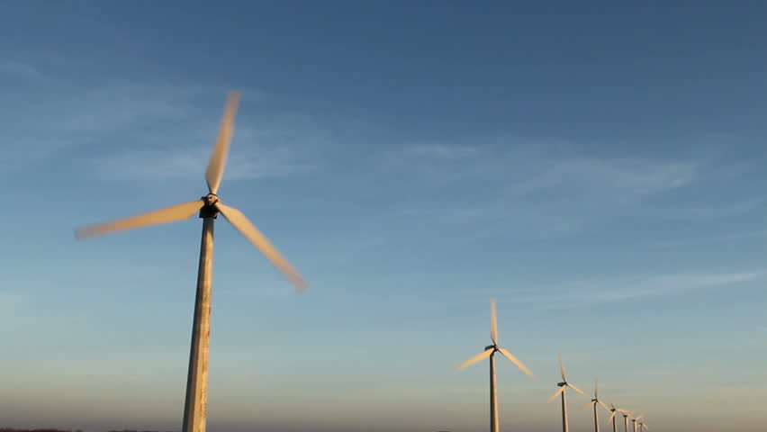 Row of wind turbines with rotating blades.