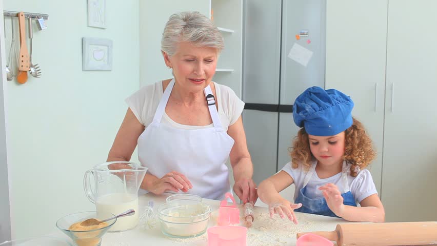 Grandmother and her grand daughter cooking together in the kitchen