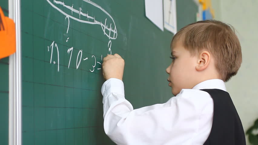 schoolboy, child wrote on a blackboard, lesson in school