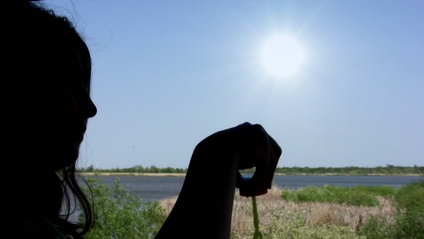 Young woman`s silhouette playing with soap bubbles