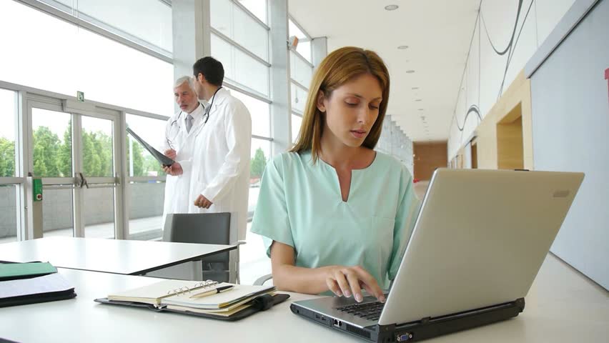Nurse working on laptop computer in hospital