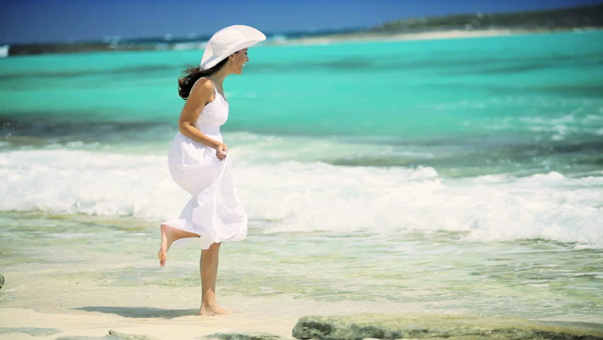 Beautiful elegant female reveling in her lifestyle beside a tropical ocean