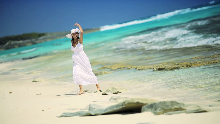 Beautiful elegant female reveling in her lifestyle beside a tropical ocean