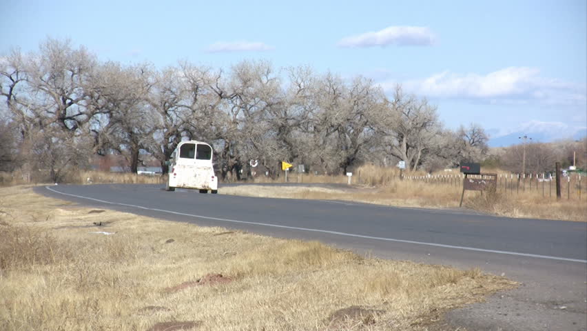 A truck and stock trailer traveling down a rural road.