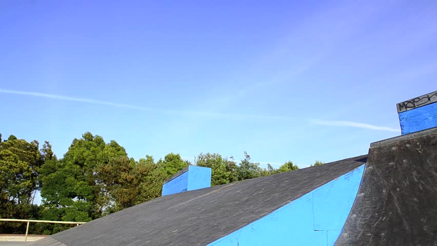 Skateboarder flying over a ramp on sunset at the local skatepark.