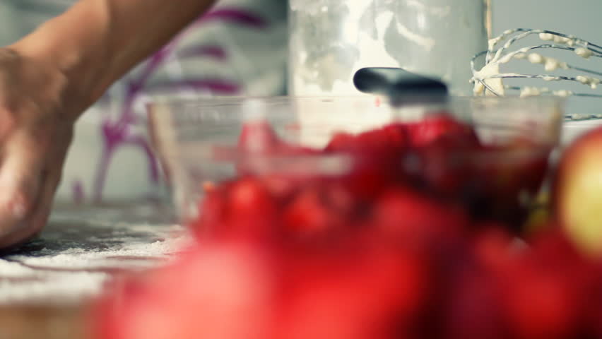 Female hands in flour kneading dough on table, dolly shot