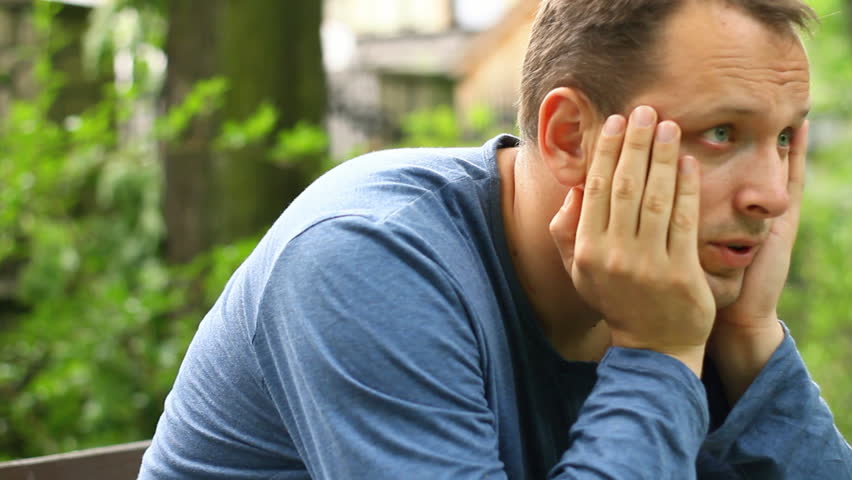 Sad young man portrait outdoors, camera stabilizer shot