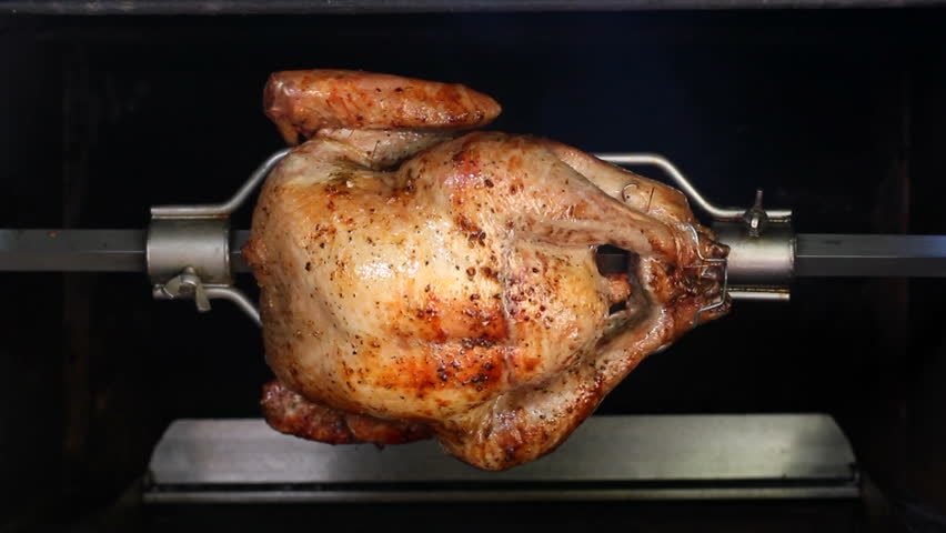 A chicken barbecued on a rotating spit. Seamless loop.