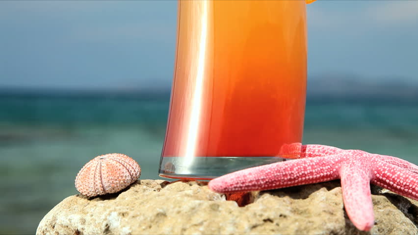 close up of cocktail down the beach, tilt shot