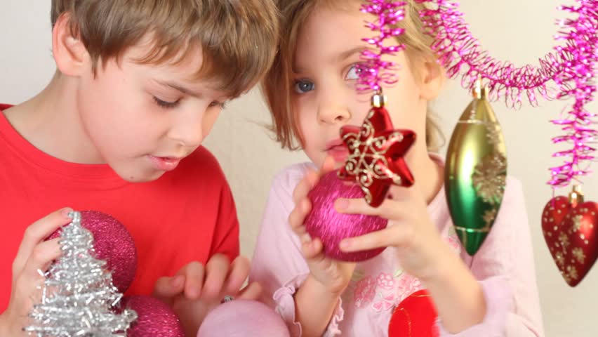 Girl and boy play with different varicoloured christmas-tree decoration