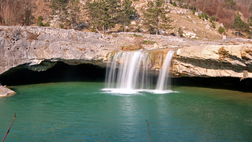 Waterfall falling into the emerald lake in Zarecki krov
