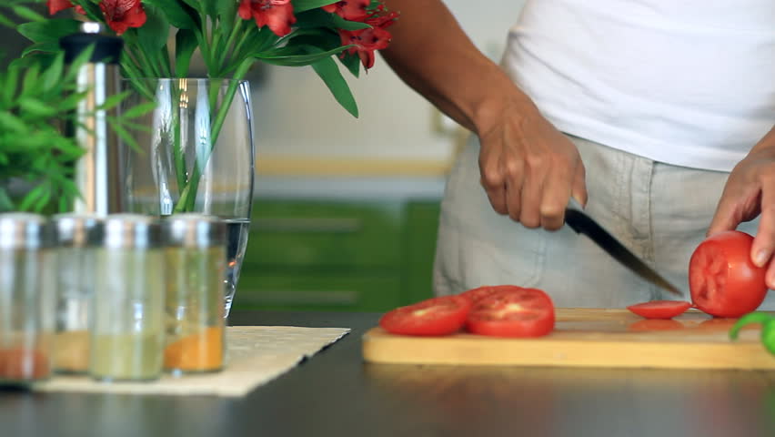Female hands slicing red tomato, dolly shot 