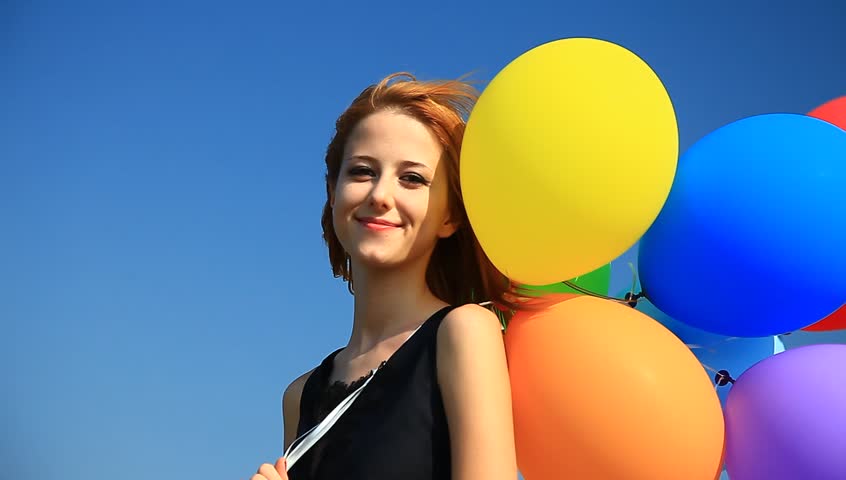 Redhead girl with color balloons.