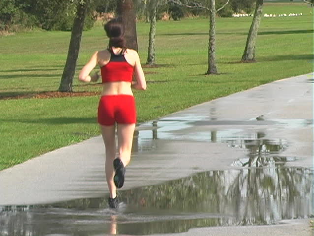 A beautiful young woman jogging outdoors away from the camera (full-length)