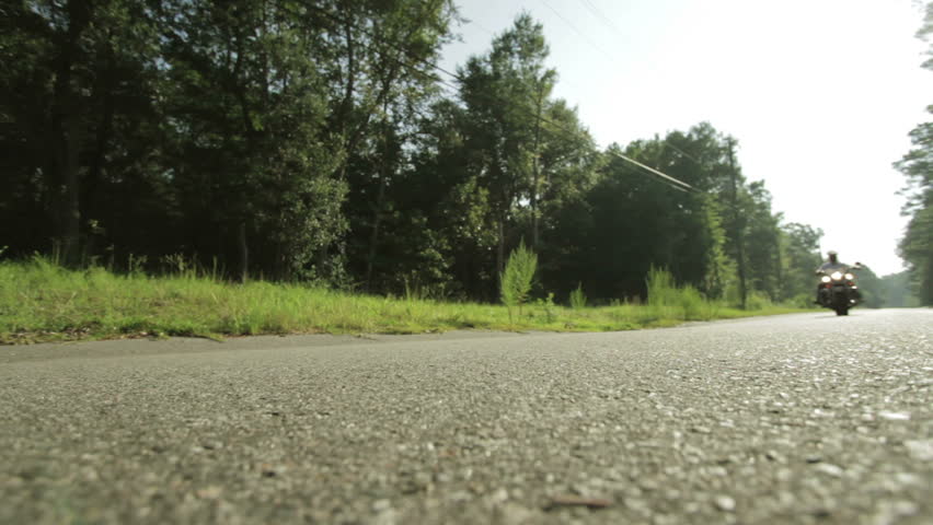 Motorcycle pulling up to camera. ultra wide angle