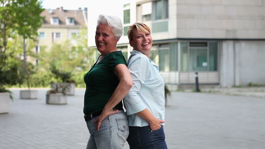 Two happy older women holding their thumbs up