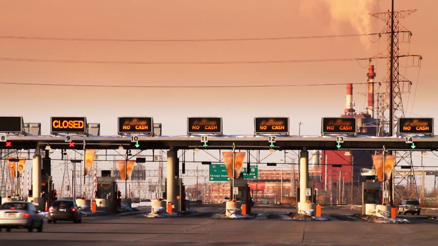 Cars arrive at a toll plaza on the highway