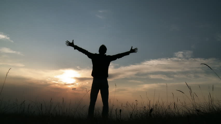 Silhouette of man on the sunset. Freedom concept.