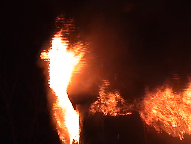 Flames engulf the roof of a house.