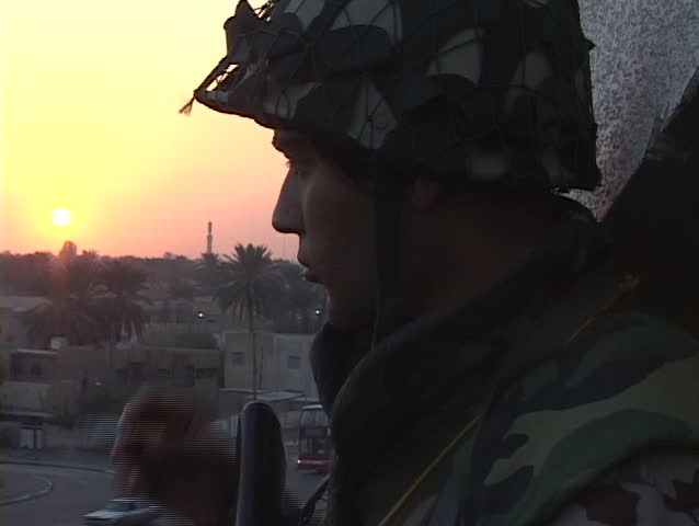 BAGHDAD - CIRCA 2003: A soldier smokes a cigarette while manning a guard post circa 2003 in Baghdad, Iraq.