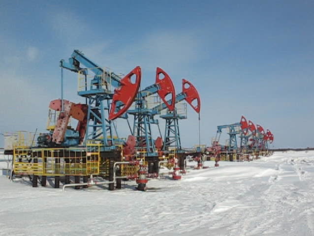 Oil pump jack in work. Oil industry in West Siberia. Siberian frost in sunny day.
