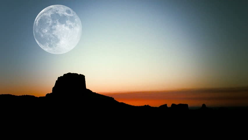 Time-lapse of moon moving down over rock formation