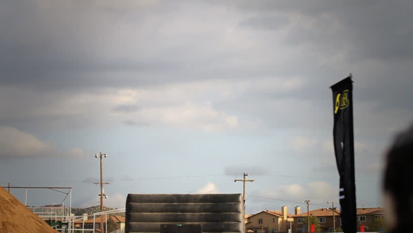 Static shot of multiple riders jumping ramp