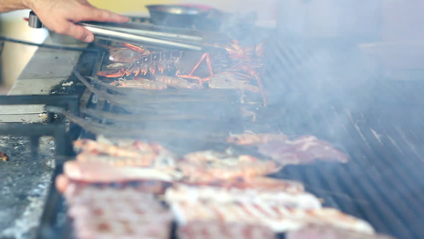 Grilling lobsters, fish and shrimps on a barbecue. HD 1080i. Shallow DOF. Selective Focus.