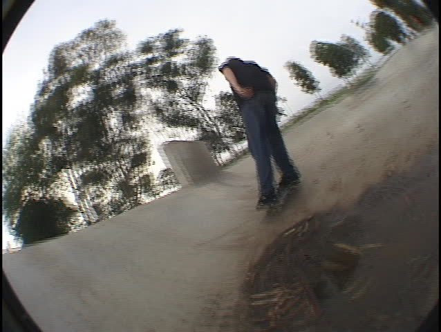 A skateboarder travels the edges and walls of a skate park.