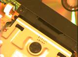 A compact disk slides through a slot.