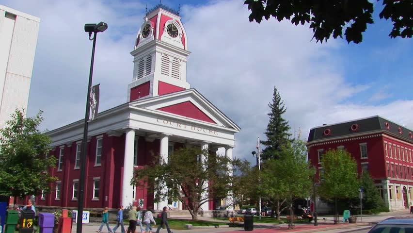 Pedestrians and vehicles travel pass a historic court house in Montpelier, Vermont.