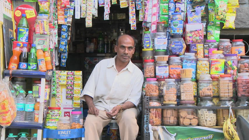 INDIA - CIRCA 2010: People walking in front of man sitting in front of his street stall circa 2010 in India. The 467-million worker Indian labour force is the world's second-largest.