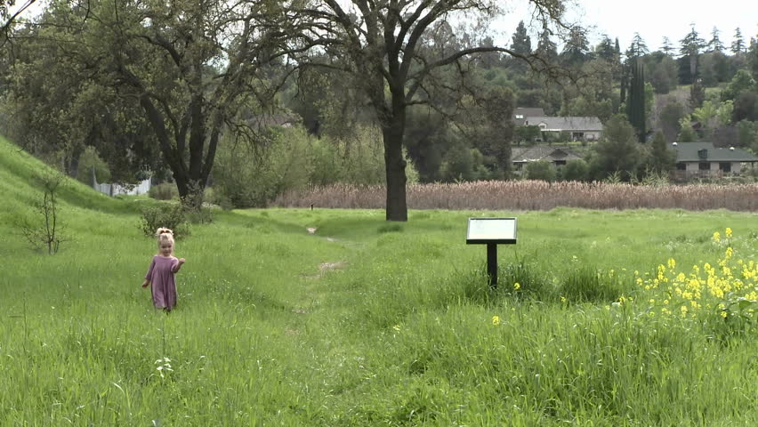 OJAI, CA - CIRCA 2009: A girl walking through a restored wetlands at the Ojai Meadow Preserve circa 2009 in Ojai, California. Besides the ecological value of the restored wetlands, they act as a sponge to soak up storm runoff and prevent flooding. 