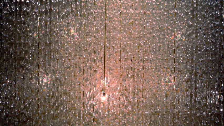 Curtain made of glass beads at background of tiled wall