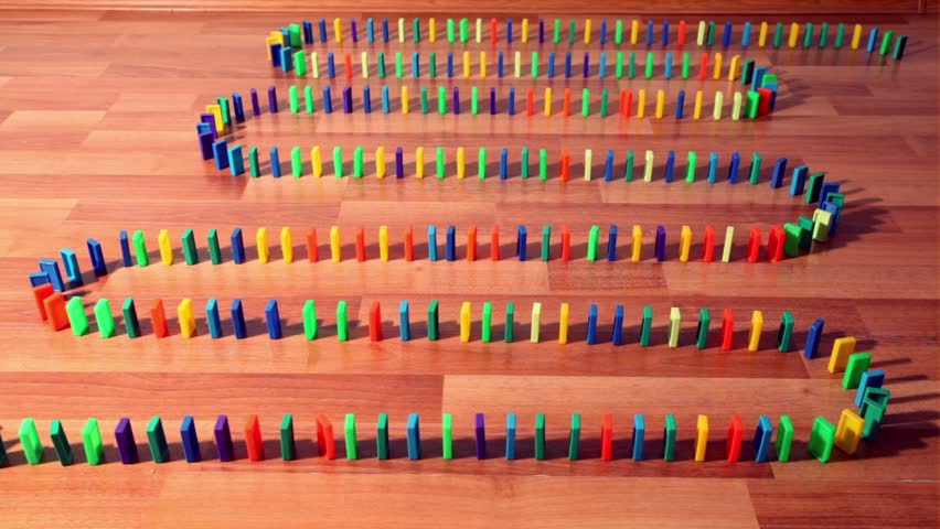 Dominoes row begin to fall down one by one but stop, kid try to resume this process