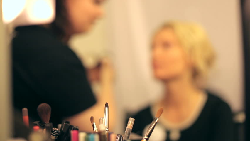 Professional makeup artist putting cosmetics.  Focus on the instrument.