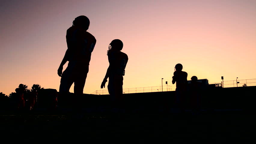 Football players warming up and having a catch
