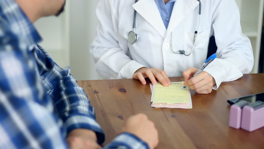 Female doctor writing rx prescription for male patient