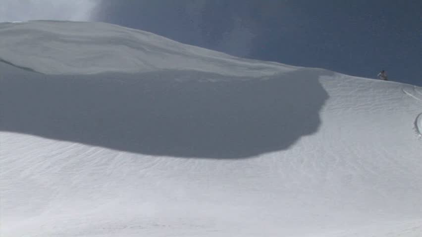 WS of a snowboarder moving fast down a slope