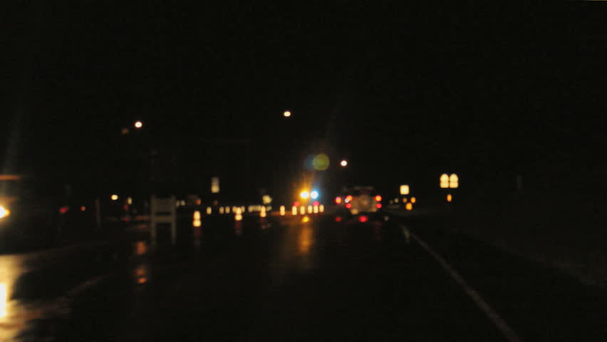 drive by soft focus of police blockade in road at night