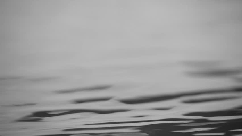 Black water background. Small black water waves with copy space. Footage.