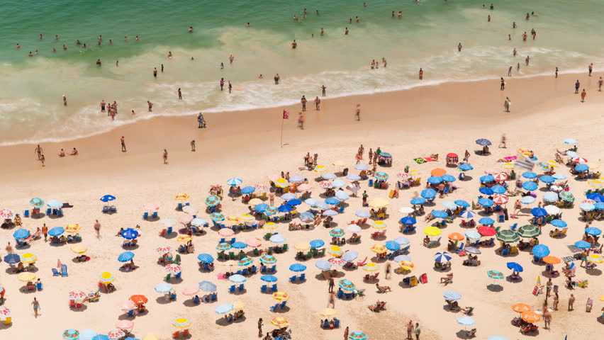 Sunbathers Lie In The Sand Of Copacabana Beach In Rio De Janeiro
