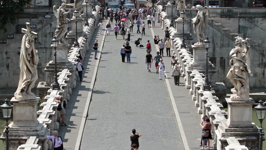 Tourists crossing historic and famous Bridge of Angels 25, 2011. Castel Sant Angelo in Rome looking from famous round castle. Tomb of Roman emperor Hadrian, called Hadrian's mole.